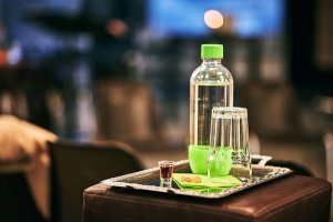 Water bottle and glass on a silver tray with small wine cup and bread for church communion